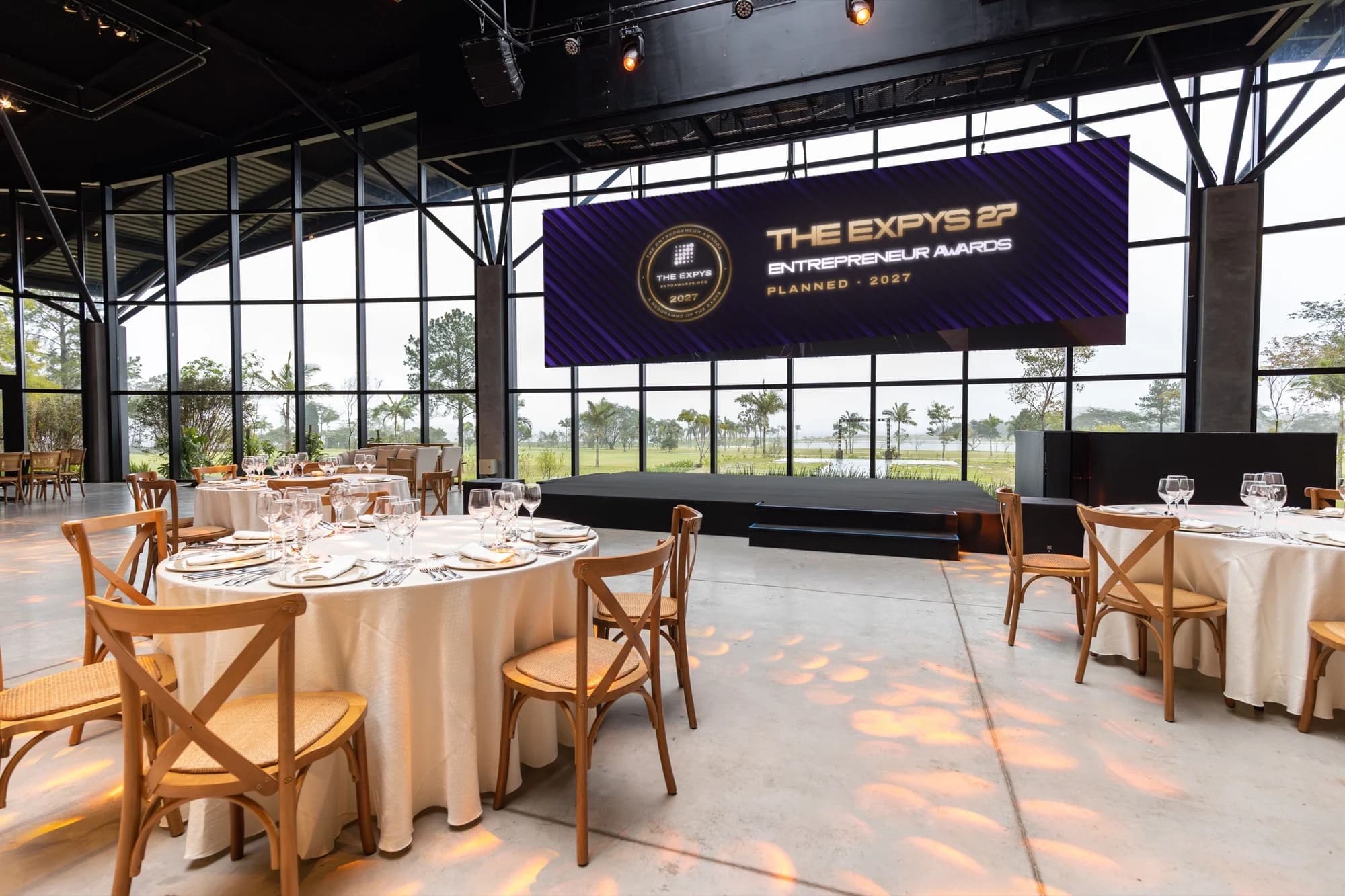 A glasshouse room set for the Entrepreneur Awards in daylight