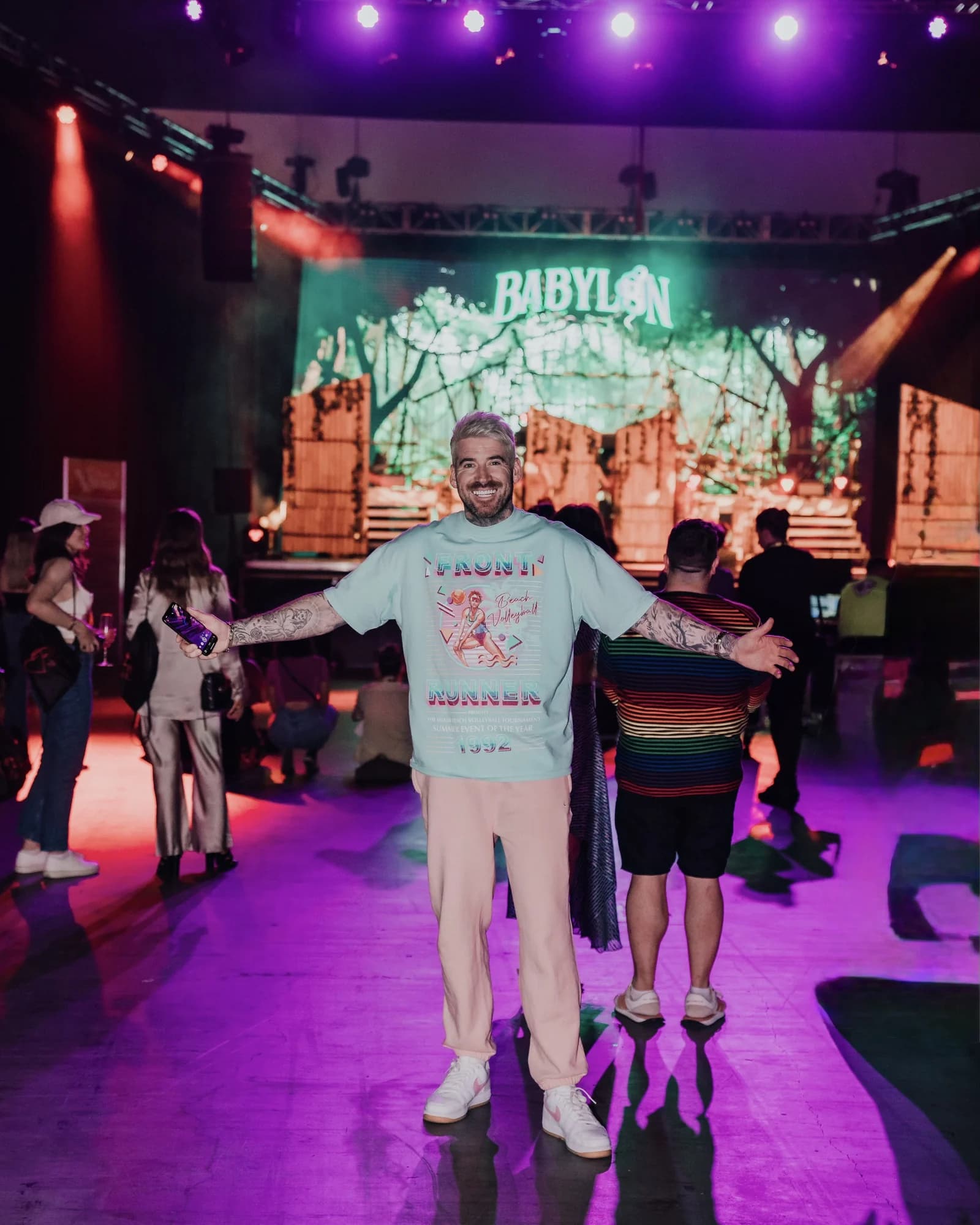 Kevin Mack on stage with his arms wide in front of the Babylon Live backdrop