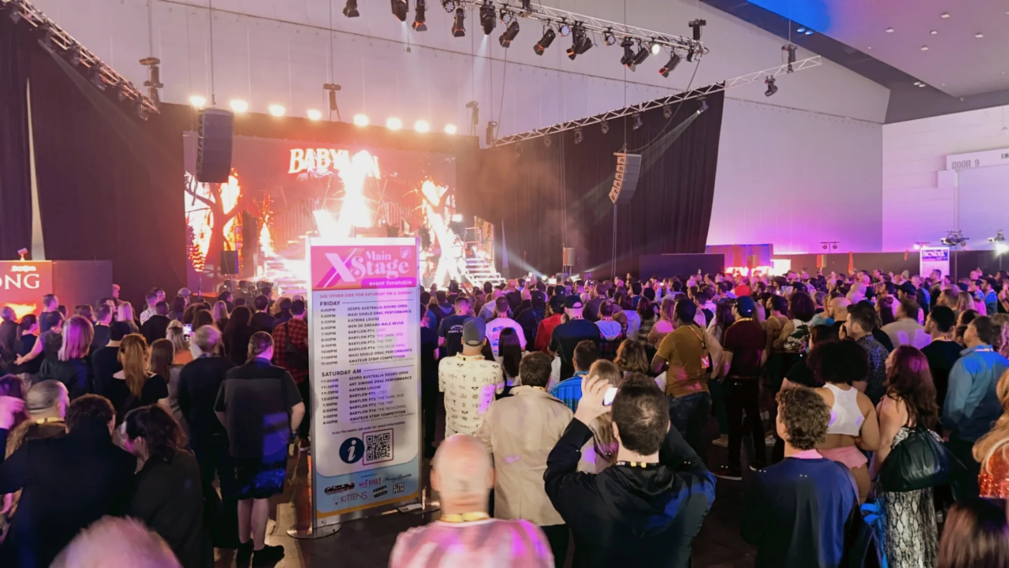 A crowd in front of the main stage with Babylon Live performing under the lights